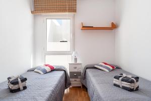 two twin beds in a room with a window at Casa Alena in Conil de la Frontera +20 photos