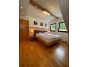 a bedroom with a bed and wooden floors at Ferienwohnung Zur Imme in Lindau