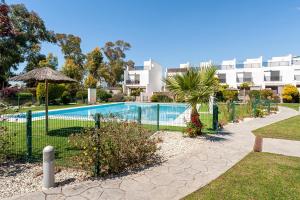 a swimming pool at a resort with a building at Casa Alena in Conil de la Frontera
