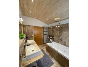 a bathroom with a large tub and a sink and a bath tub at Ferienwohnung Zur Imme in Lindau +35 photos