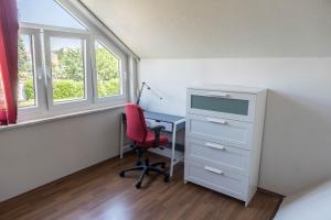 an office with a desk and a red chair at Haus Jäschke in Bremerhaven