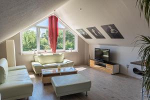 a living room with a couch and a tv at Haus Jäschke in Bremerhaven