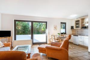 a living room with couches and a table and a kitchen at Gästehaus Vogel in Horumersiel
