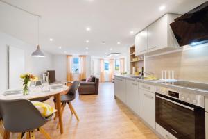 a kitchen and living room with a table and chairs at Ferienwohnung Apfelwiese in Meßstetten