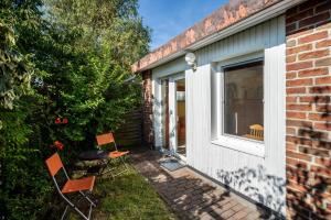 eine Terrasse mit zwei Stühlen, einem Tisch und einem Fenster in der Unterkunft Apartment Sonnengärtchen in Blankenburg