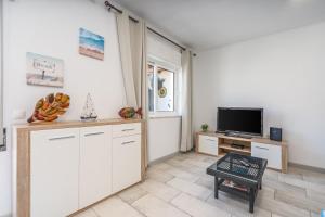 a kitchen with white cabinets and a flat screen tv at Casa Terrace Carvoeiro in Carvoeiro