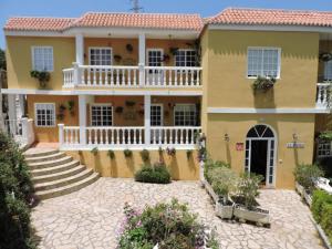 a large yellow house with a white balcony at La Granja in Los Llanos de Aridane