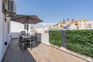 a table and chairs on a balcony with an umbrella at Casa Terrace Carvoeiro in Carvoeiro