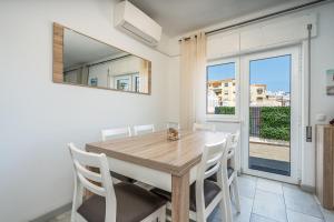 a dining room with a wooden table and white chairs at Casa Terrace Carvoeiro in Carvoeiro