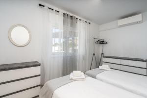 two beds in a white room with a mirror at Casa Terrace Carvoeiro in Carvoeiro