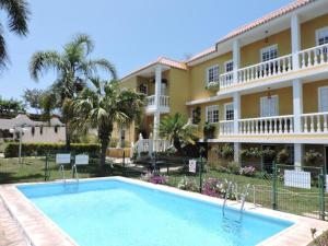 a resort with a swimming pool in front of a building at La Granja in Los Llanos de Aridane