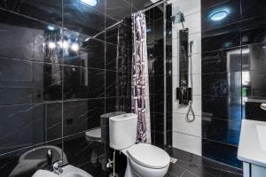 a black tiled bathroom with a toilet and a shower at Casa Terrace Carvoeiro in Carvoeiro +21 photos
