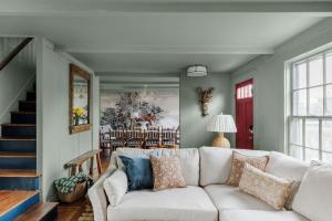 a living room with a white couch and a staircase at Historic Island Home Heated Pool in Nantucket