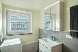 a white bathroom with a sink and a mirror at Ferienwohnung Reck in Aulendorf