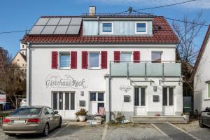 a white house with a car parked in front of it at Ferienwohnung Reck in Aulendorf