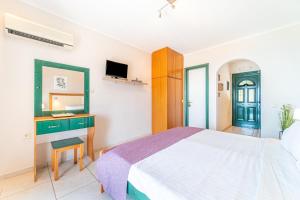 a bedroom with a bed and a desk and a mirror at Spyridoula Studio 12 in Paleokastritsa