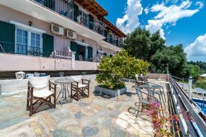 a patio with chairs and tables in front of a building at Spyridoula Studio 12 in Paleokastritsa
