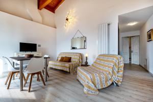 a living room with a bed and a table and chairs at Nonna Gina in Tignale