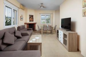 a living room with a couch and a tv at Villa ju-mi in El Cerro