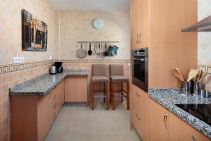 a kitchen with wooden cabinets and granite counter tops at Villa ju-mi in El Cerro