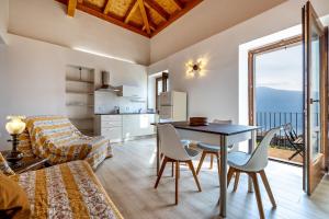 a living room with a table and chairs and a kitchen at Nonna Gina in Tignale
