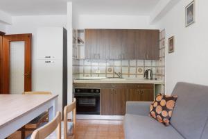 a kitchen with wooden cabinets and a table and a couch at Marilleva 900 Terminal in Mezzana