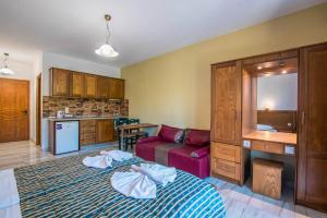 a bedroom with a bed and a kitchen with a couch at Mirage Arillas Studio Type C16 in Arillas +13 photos