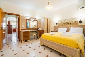 a bedroom with a yellow bed and a desk at Livadia Beach Suite in Tílos