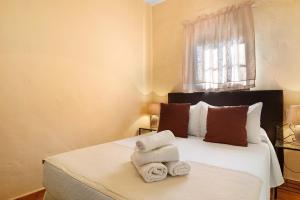 a bedroom with a bed with towels on it at Casa Dorca 1 in Conil de la Frontera +19 photos