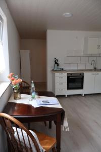a kitchen with a wooden table with chairs and a table and a kitchen at Ferienwohnung Spielmann in Sauldorf