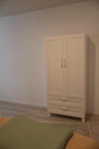 a bedroom with a white cabinet and a rug at Ferienwohnung Spielmann in Sauldorf