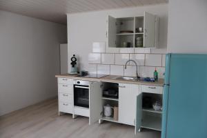 a kitchen with white cabinets and a sink at Ferienwohnung Spielmann in Sauldorf