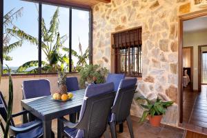 a patio with a table and chairs and a stone wall at Casa Dorca 1 in Conil de la Frontera
