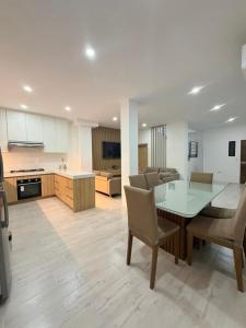 a kitchen and living room with a glass table and chairs at Vive Manta como nunca antes! in Manta
