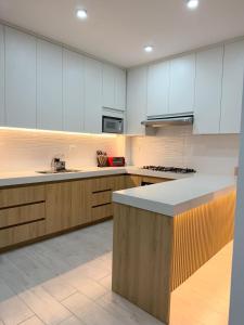 a large kitchen with white cabinets and a counter at Vive Manta como nunca antes! in Manta +7 photos