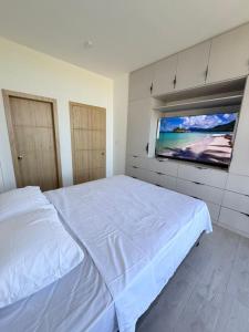 a white bedroom with a large bed and a window at Vive Manta como nunca antes! in Manta