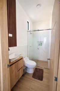 a bathroom with a toilet and a glass shower at Vive Manta como nunca antes! in Manta