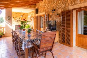 a dining room with a table and chairs and a television at Can Lopez Vara in Campos
