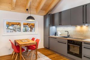 a kitchen with a wooden table and red chairs at Apartment Alte Mühle in Scharnitz