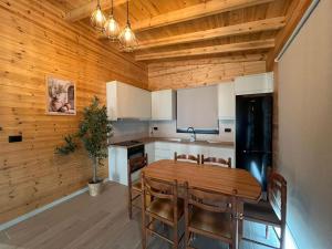 a kitchen with a wooden ceiling with a table and chairs at Villa Manuel in Bajkaj