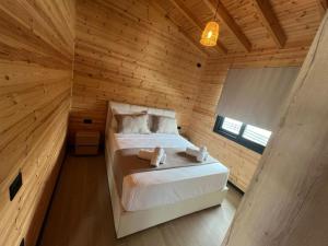 a bedroom with a bed in a wooden room at Villa Manuel in Bajkaj