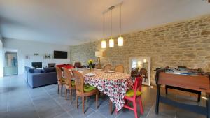 a dining room with a table and chairs and a couch at La maison jaune - 3ch - 6pers in Loctudy