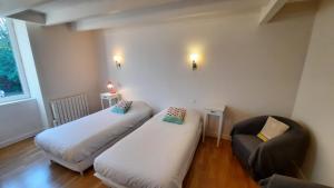 a room with two beds and a chair in it at La maison jaune - 3ch - 6pers in Loctudy
