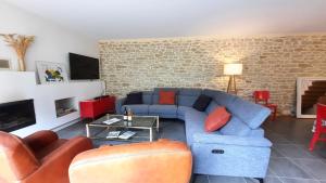 a living room with a blue couch and a brick wall at La maison jaune - 3ch - 6pers in Loctudy