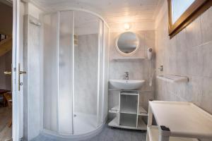a white bathroom with a shower and a sink at Casa Camilla in Ledro