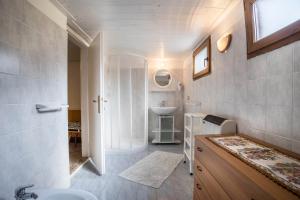 a bathroom with a sink and a toilet and a mirror at Casa Camilla in Ledro