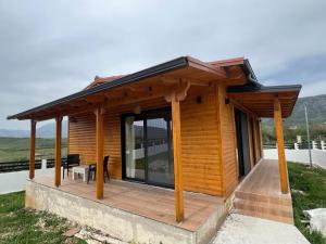 a small wooden cabin with a roof at Villa Manuel in Bajkaj