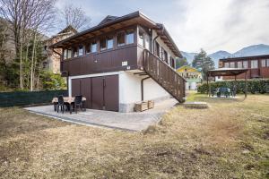 a house in the mountains with a table in front of it at Casa Camilla in Ledro