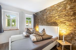 a room with two beds and a stone wall at Ferienhaus Enztal in Zweifelscheid