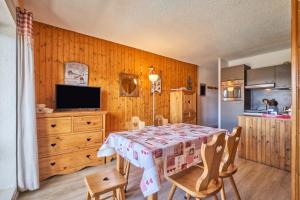 a dining room with a table and chairs at Studio Alpe d'huez in LʼHuez